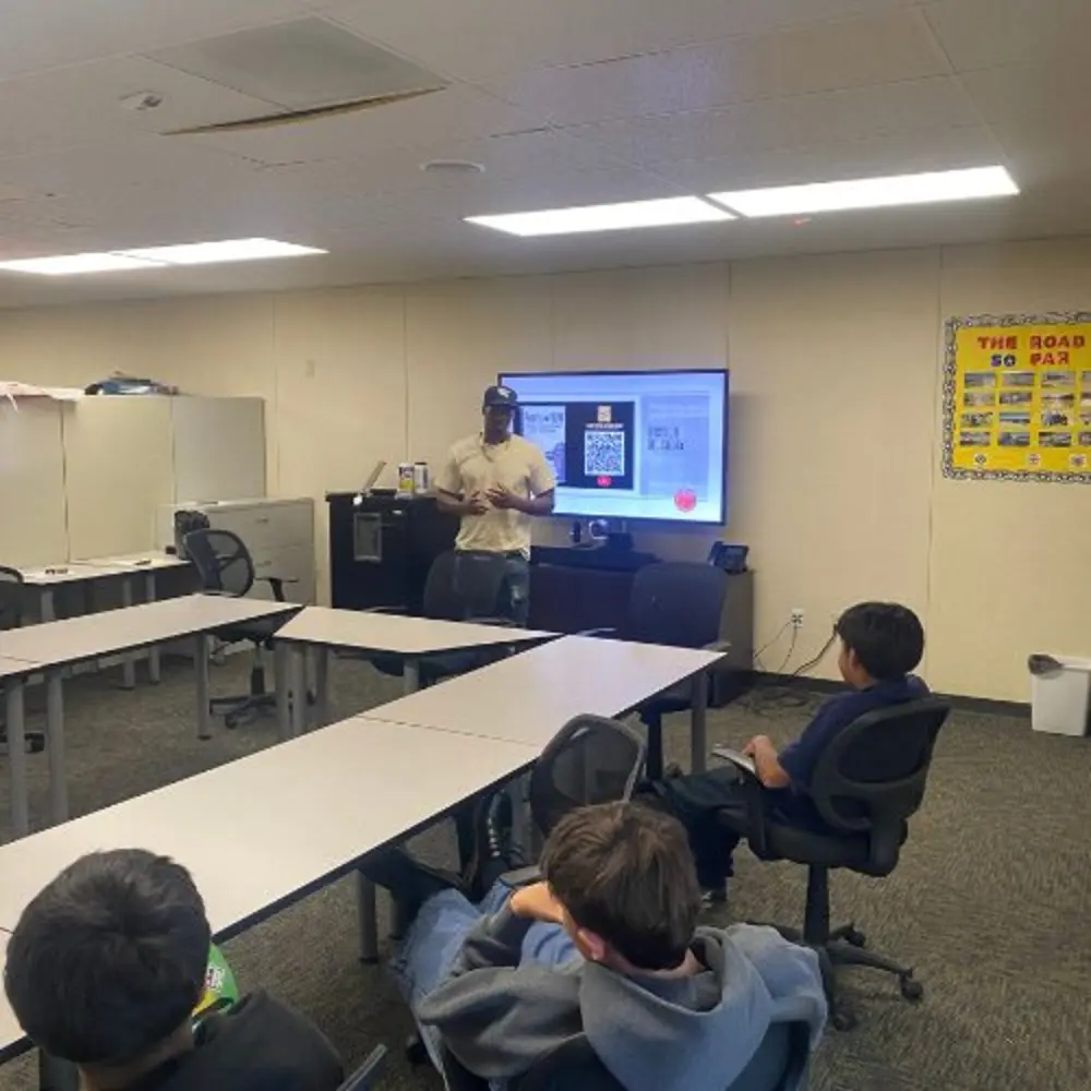 Classroom photograph from the studio’s existing website, showing a facilitator presenting and seated learners